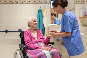 Female home health aide helping elderly patient