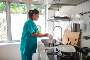 Nurse washing dishes in kitchen