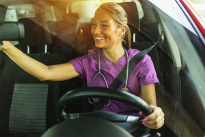 Young nurse driving to store for client